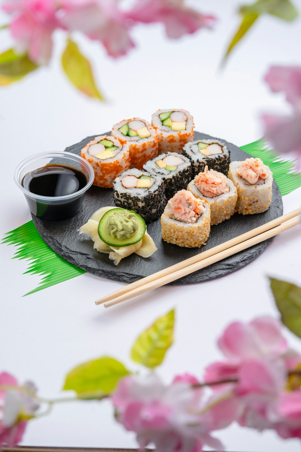 An assortment of sushi rolls served on a slate plate.