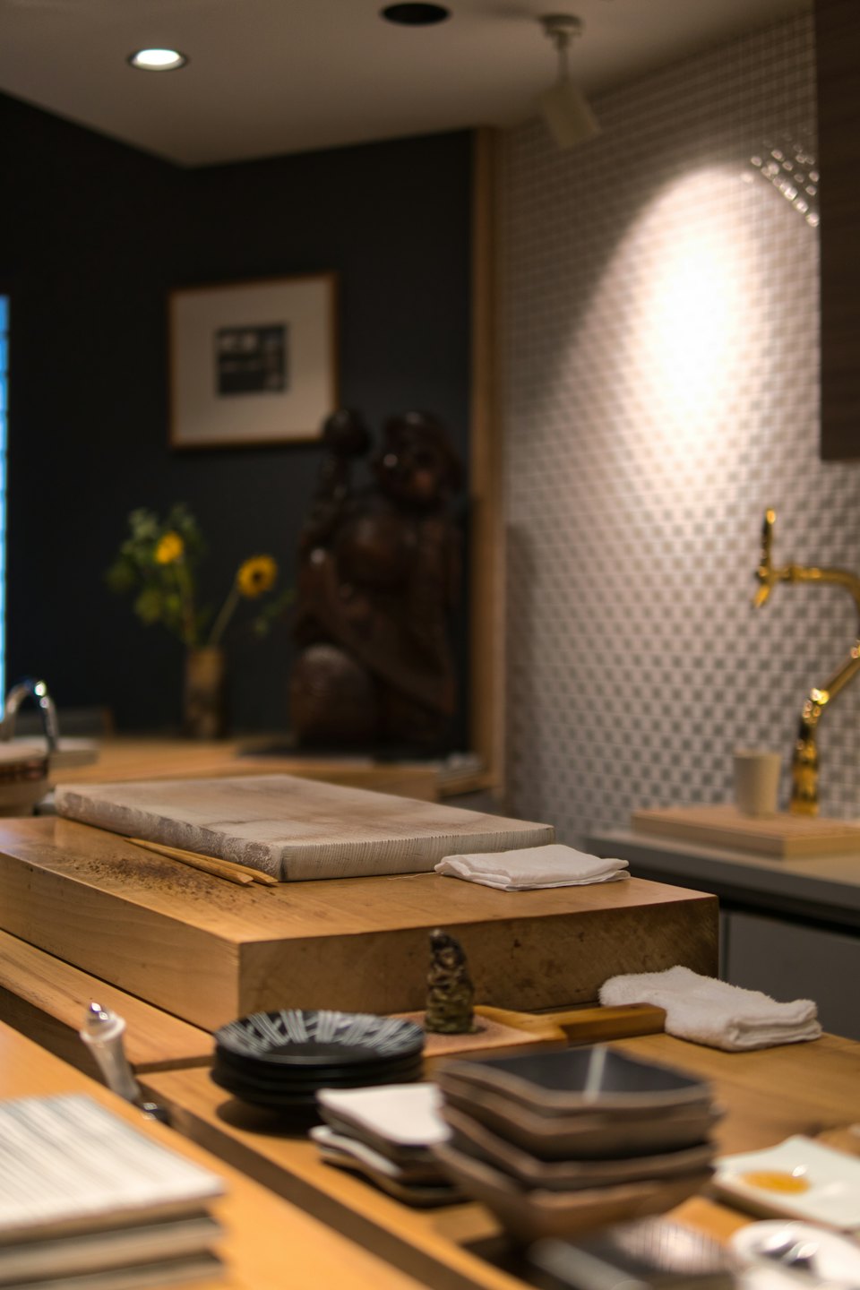 Sushi counter prepared for service with dishes and chopsticks.