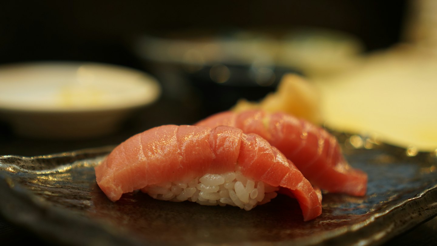 Two pieces of fresh pink tuna nigiri served on a plate.