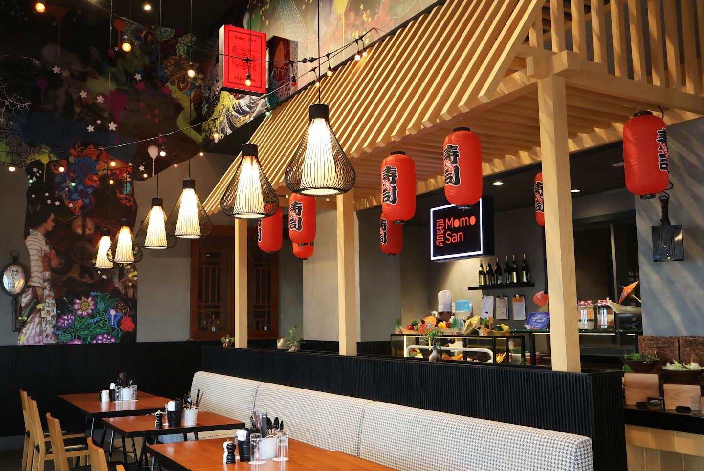 Modern Japanese restaurant interior with booth seating and service counter.